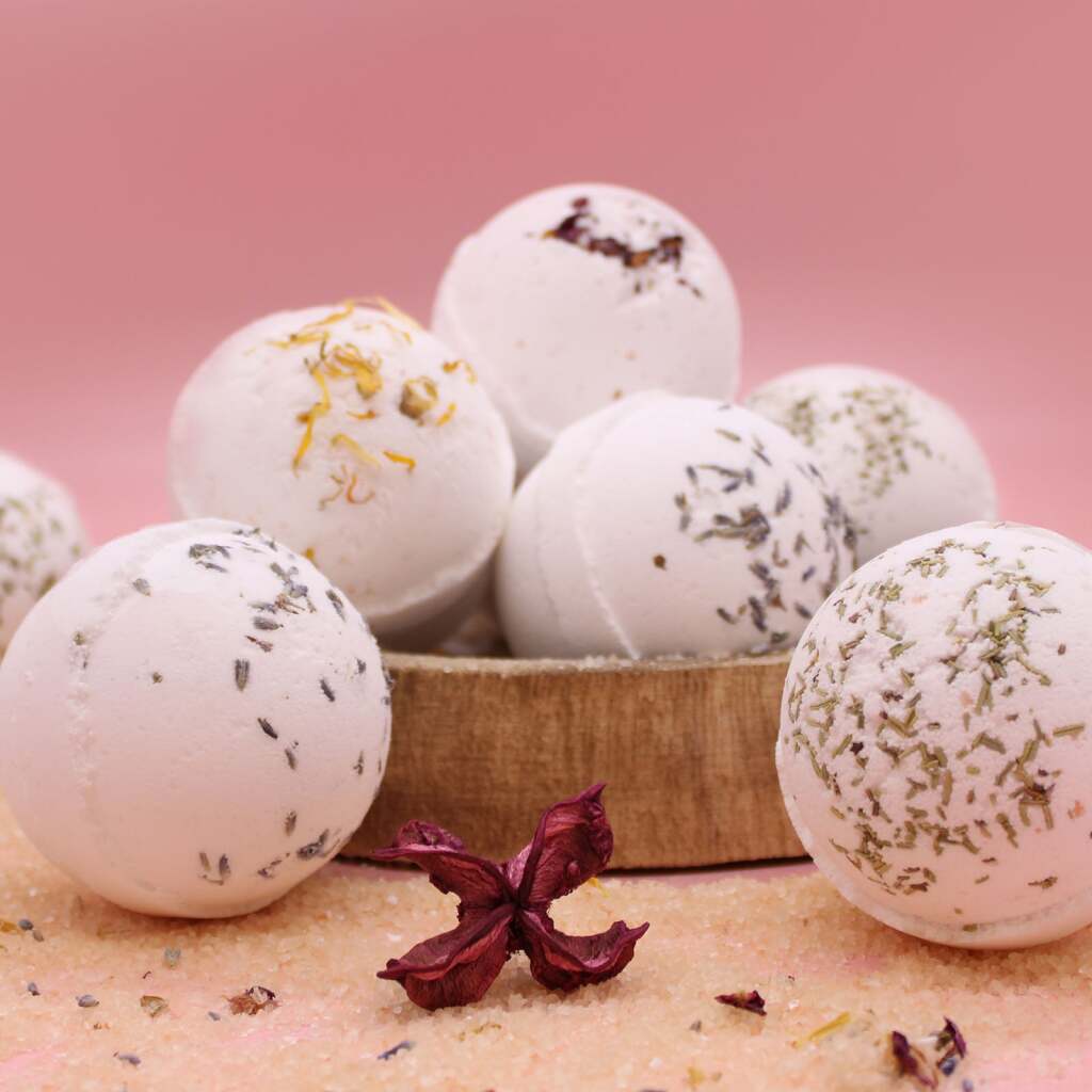 Bath bombs with natural ingredients on a pink background