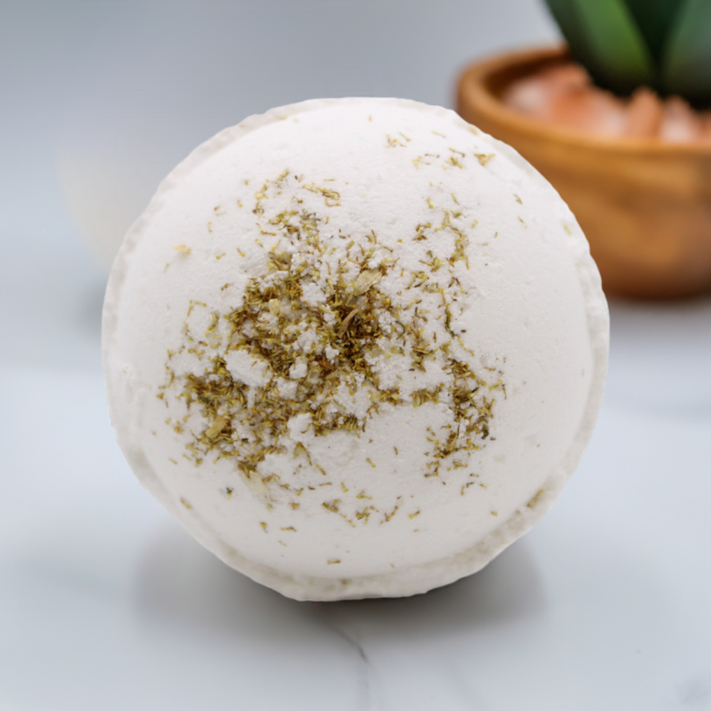 White bath bomb with green flecks on a light surface